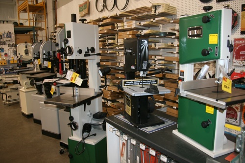 Band saws and router tables flow back one wall to the dust collection area at the back of the store. Stationary tools and portable products occupy the right front and center of the store,  essentially surrounding the checkout area near the front center of the store.   