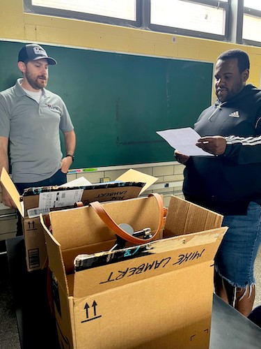 Mike Lambert, left, and Stark High School’s Dominique Guyton go through the M. K. Morse Company’s donation to the school’s science program.
