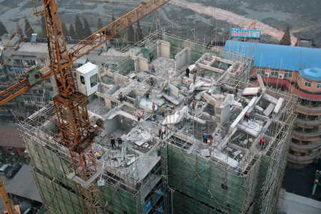 Workers demolish a 20-story building that was illegally built in Wuhan, Hubei province, in this Nov 26, 2009. [File photo / China Daily] 
